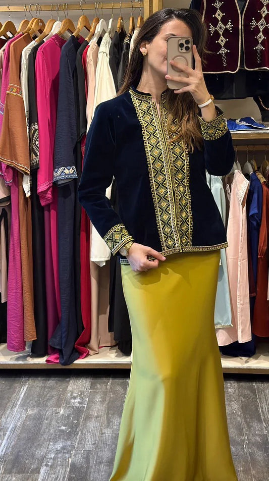 Femme en takchita algérienne bleu marine brodée dorée et jupe longue jaune dans boutique Lyne Créations